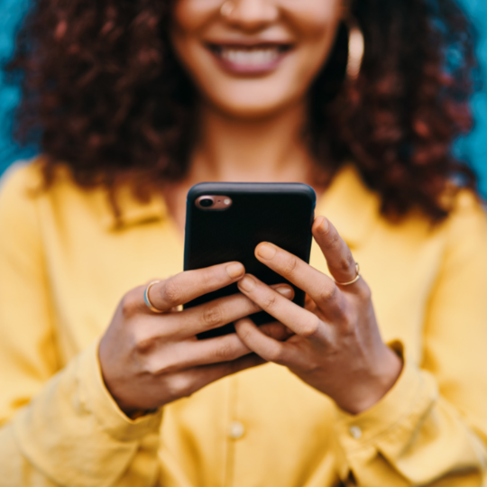 What is a Digital Footprint & Why is it Important? image of black woman on smartphone and smiling