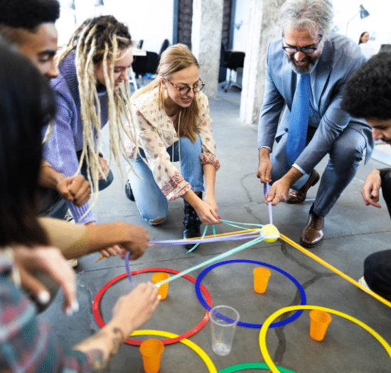 Creative Staffing Agency Columbus - image of diverse team of employees and boss in a creative office setting playing a team building game in their office space